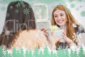 Composite image of beautiful young woman receiving a gift box on