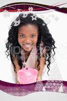 Young woman smiling at the camera is holding a piggy bank in her hands