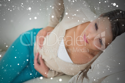 Composite image of woman lying on sofa looking sick