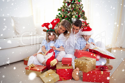 Portrait of a happy family opening christmas gifts