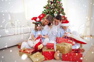 Portrait of a happy family opening christmas gifts