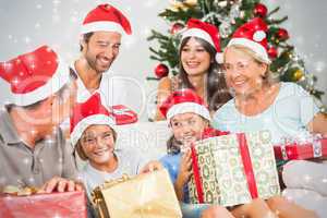Composite image of happy family at christmas swapping gifts