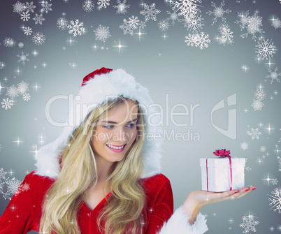 Composite image of pretty girl in santa outfit holding gift