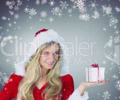 Composite image of pretty girl in santa outfit holding gift