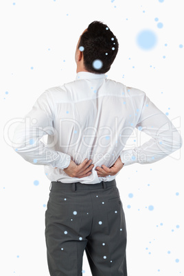 Composite image of portrait of the painful back of a young busin