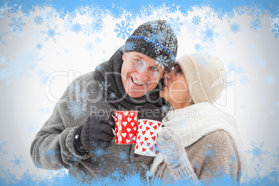 Happy mature couple in winter clothes holding mugs