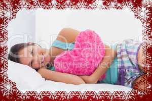 Composite image of happy woman lying in bed