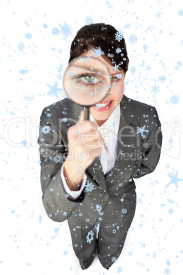 Composite image of young businesswoman looking through magnifyin