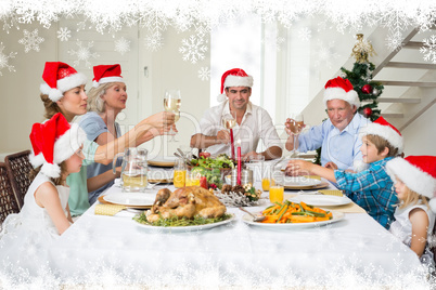 Composite image of family toasting wine while having christmas m