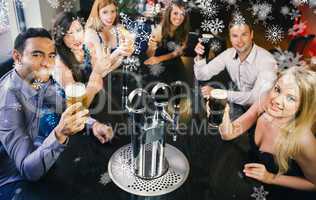 Composite image of attractive friends raising glasses up smiling