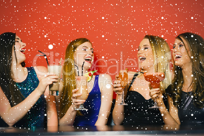 Composite image of laughing friends holding cocktails