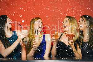 Composite image of laughing friends holding cocktails