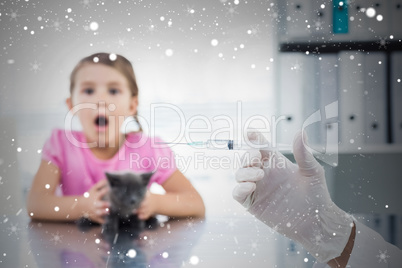 Composite image of vet holding syringe with socked girl holding