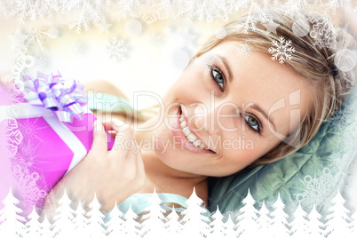 Composite image of cheerful woman holding a present