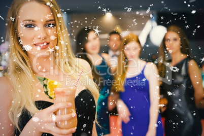 Blonde woman standing in front of her friends holding cocktail