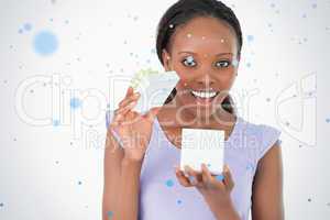 Close up of woman opening a present against a white background