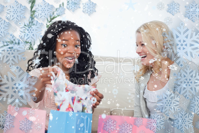 Two laughing women look at clothes they bought