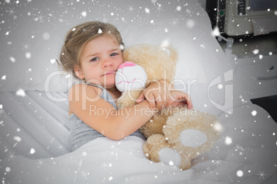 Composite image of cute girl embracing teddy bear in hospital be