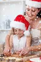 Composite image of mother and little girl baking christmas cakes