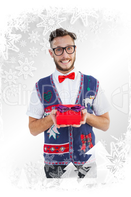 Composite image of geeky hipster offering christmas gift