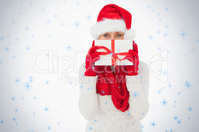 Festive woman looking at camera holding a gift