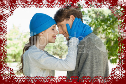 Cute couple standing in the park in hats and scarves