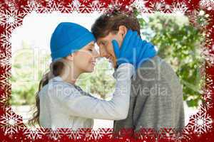 Cute couple standing in the park in hats and scarves