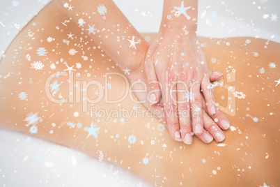 Woman receiving back massage at spa center