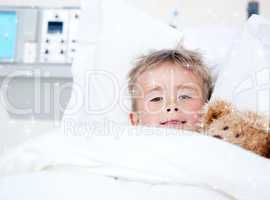 Composite image of sick adorable little boy lying in a hospital