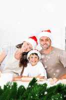 Composite image of happy family baking christmas cookies togethe