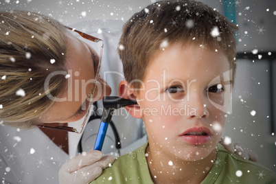 Composite image of boy being examined by doctor with otoscope