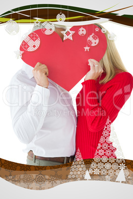 Composite image of couple embracing and holding heart over faces