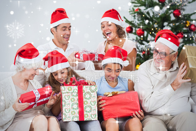 Composite image of excited family exchanging gifts at christmas