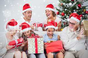 Composite image of excited family exchanging gifts at christmas