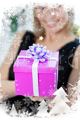 Blond woman opening a gift sitting on a sofa