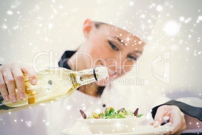 Smiling woman chef dressing a salad
