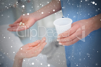 Composite image of nurse giving drugs to a patient