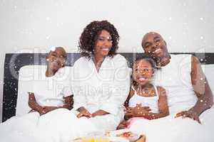 Happy family having breakfast in bed