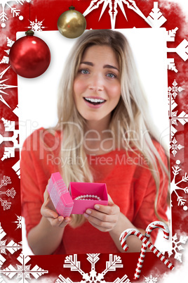 Composite image of surprised blonde woman opening gift