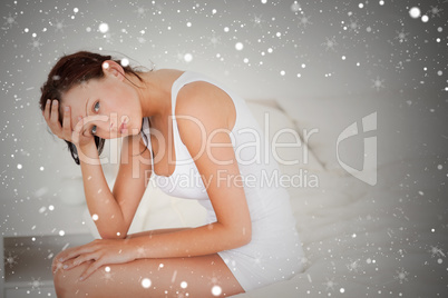 Composite image of ill feeling woman sitting on her bed
