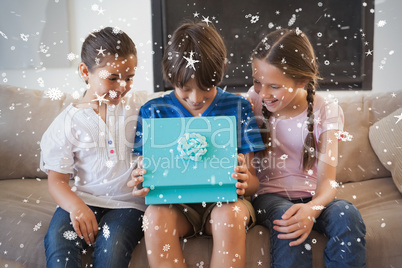 Composite image of happy young kids with gift box