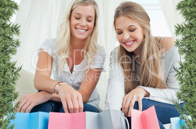 Smiling girls looking into the bags below them