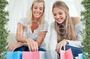 Smiling girls looking into the bags below them