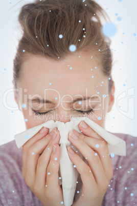 Composite image of woman blowing nose