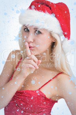 Woman in santa hat making silence gesture