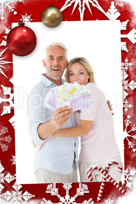 Composite image of happy couple flashing their cash