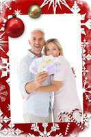 Composite image of happy couple flashing their cash