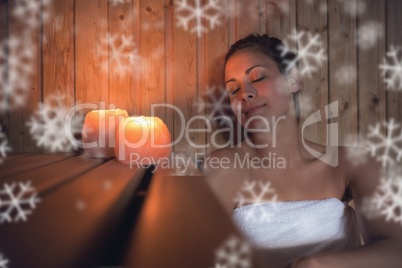 Happy brunette woman sitting in a sauna