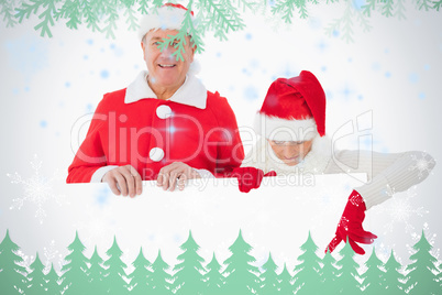 Festive older couple smiling and holding poster