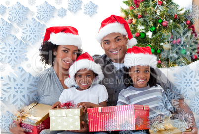 Composite image of family holding christmas presents